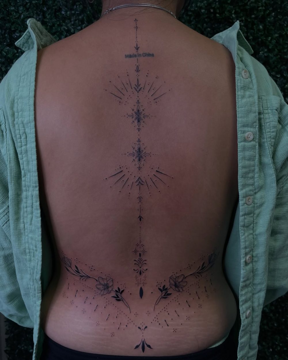 Fine line ornamental piece down the spine