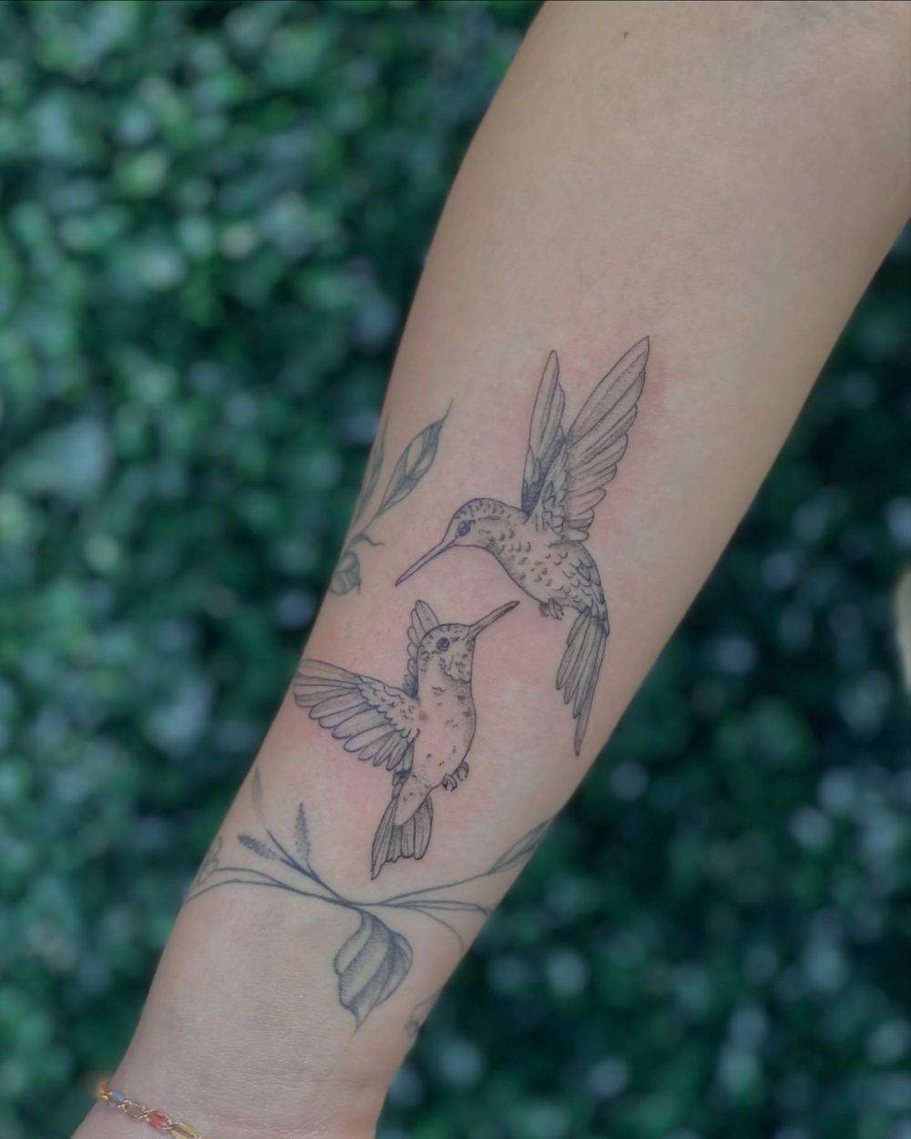Fine line hummingbird with flowers on the forearm