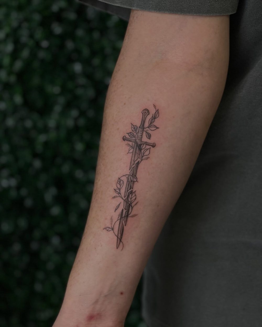 Small fine line botanical sprigs on the forearm